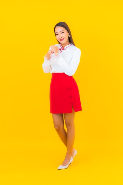 Retrato hermosa mujer asiática joven sonrisa en acción en amarillo
