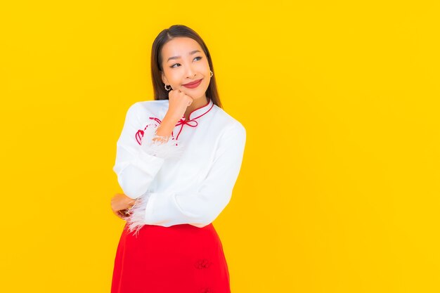 Retrato hermosa mujer asiática joven sonrisa en acción en amarillo