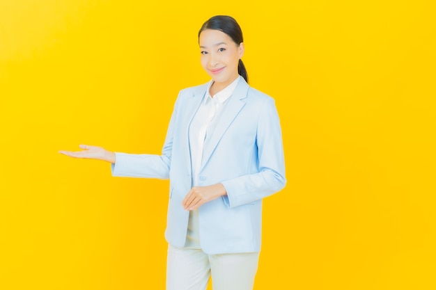 Retrato hermosa mujer asiática joven sonrisa con acción en amarillo