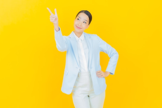 Retrato hermosa mujer asiática joven sonrisa con acción en amarillo