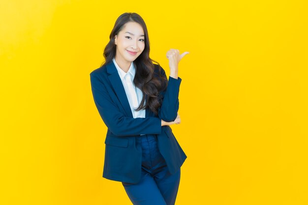 Retrato hermosa mujer asiática joven sonrisa con acción en amarillo