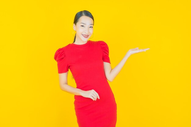 Retrato hermosa mujer asiática joven sonrisa con acción en amarillo