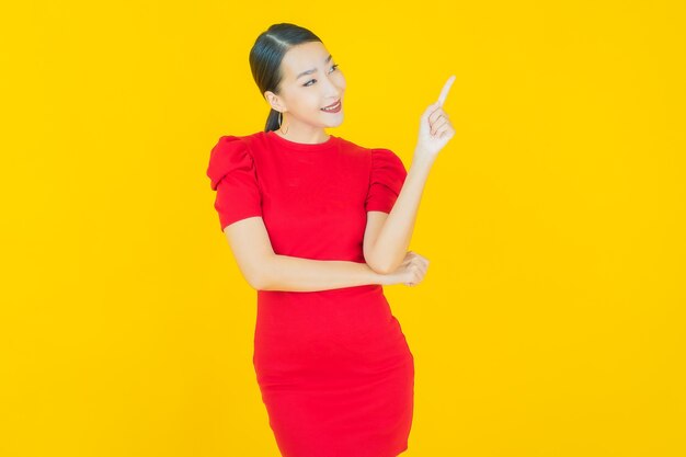 Retrato hermosa mujer asiática joven sonrisa con acción en amarillo