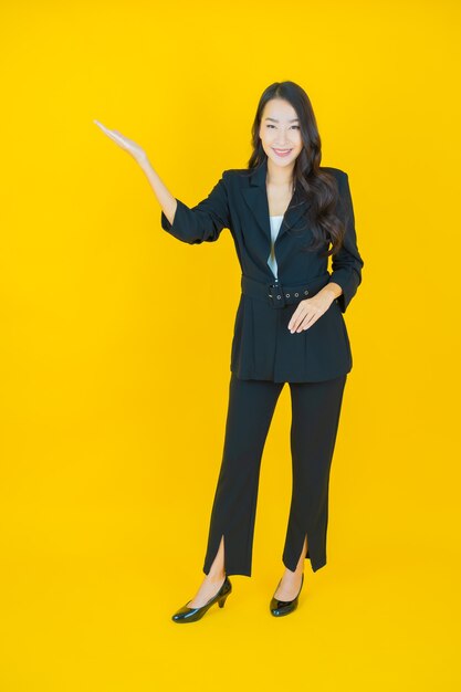 Retrato hermosa mujer asiática joven sonrisa con acción en amarillo