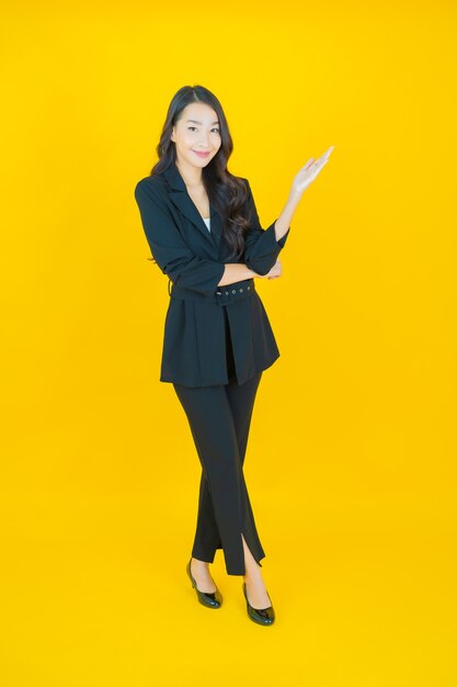 Retrato hermosa mujer asiática joven sonrisa con acción en amarillo