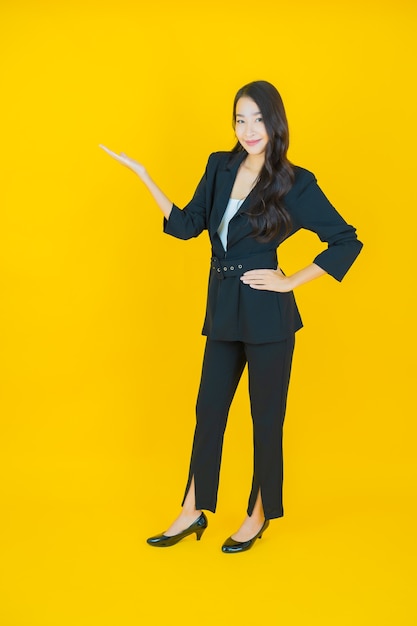 Retrato hermosa mujer asiática joven sonrisa con acción en amarillo