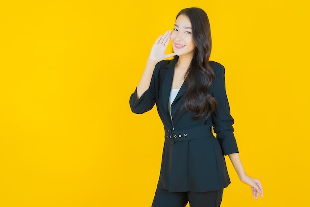 Retrato hermosa mujer asiática joven sonrisa con acción en amarillo