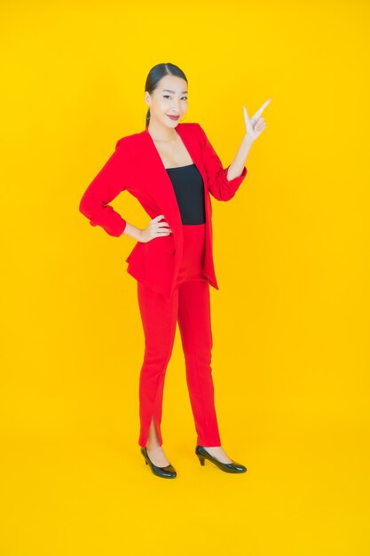 Retrato hermosa mujer asiática joven sonrisa con acción en amarillo