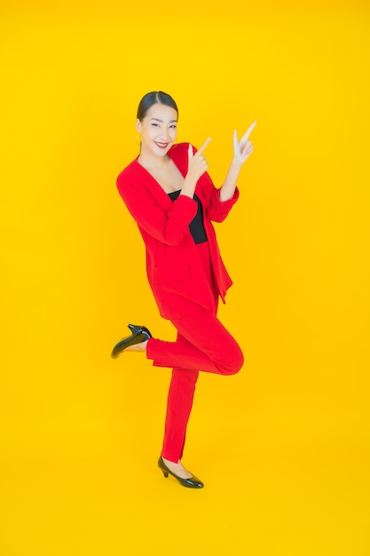 Retrato hermosa mujer asiática joven sonrisa con acción en amarillo