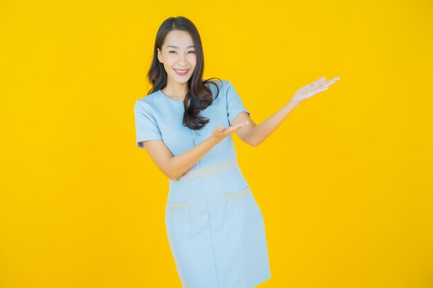 Retrato hermosa mujer asiática joven sonrisa con acción sobre fondo de color