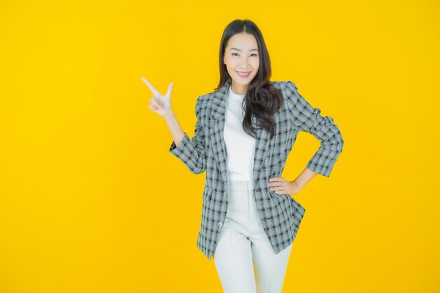 Retrato hermosa mujer asiática joven sonrisa con acción sobre fondo de color