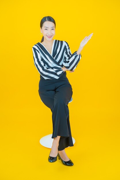 Retrato hermosa mujer asiática joven sonrisa en amarillo