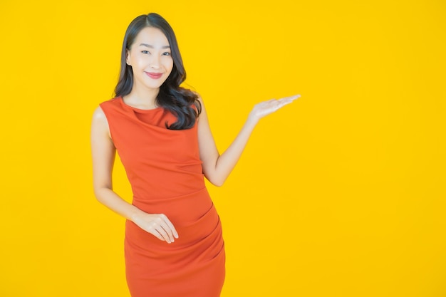 Retrato hermosa mujer asiática joven sonrisa en amarillo