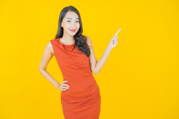 Retrato hermosa mujer asiática joven sonrisa en amarillo