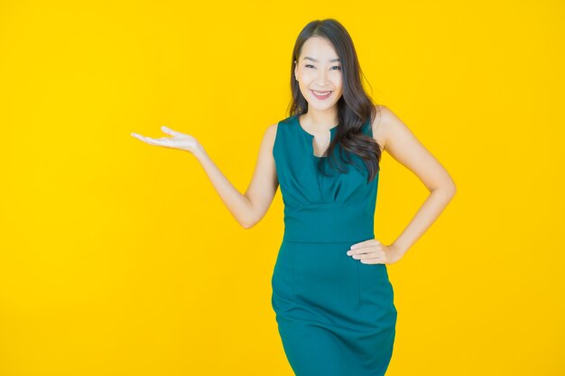 Retrato hermosa mujer asiática joven sonrisa en amarillo