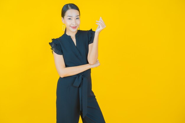 Retrato hermosa mujer asiática joven sonrisa en amarillo