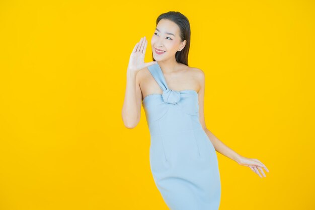 Retrato hermosa mujer asiática joven sonrisa en amarillo