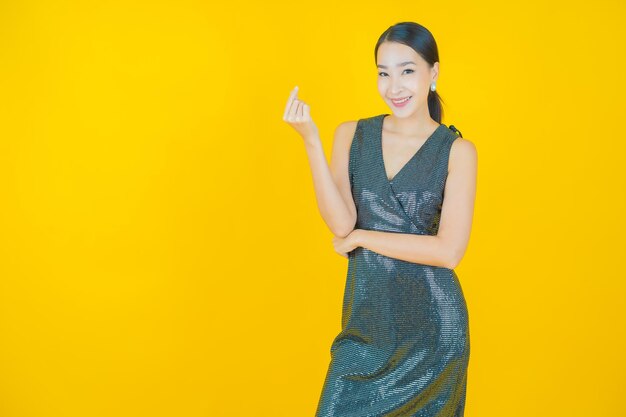 Retrato hermosa mujer asiática joven sonrisa en amarillo