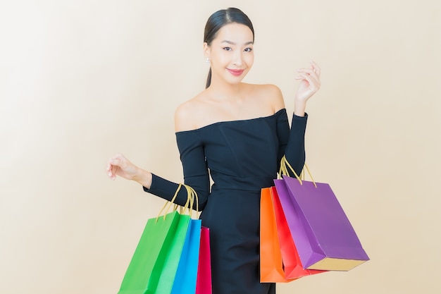 Retrato hermosa mujer asiática joven sonrisa con bolsa de compras en amarillo