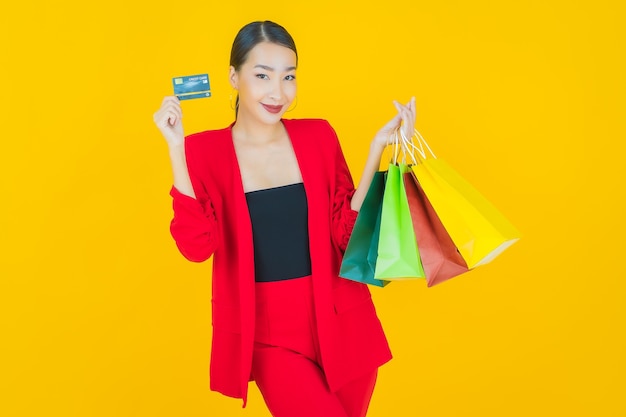 Retrato hermosa mujer asiática joven sonrisa con bolsa de compras en amarillo