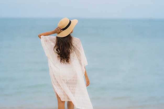 Retrato hermosa mujer asiática joven sonrisa feliz relajarse en la playa mar océano