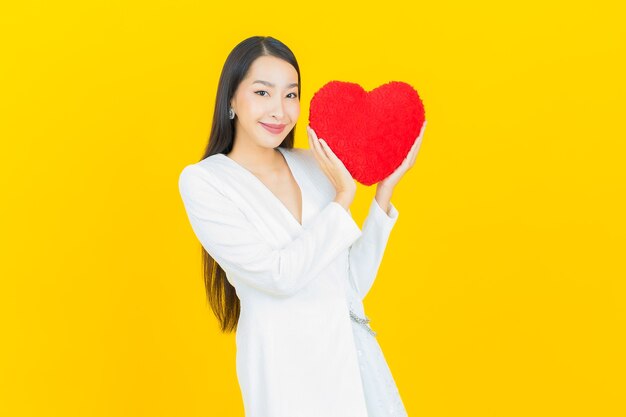 Retrato hermosa mujer asiática joven sonrisa con forma de almohada de corazón