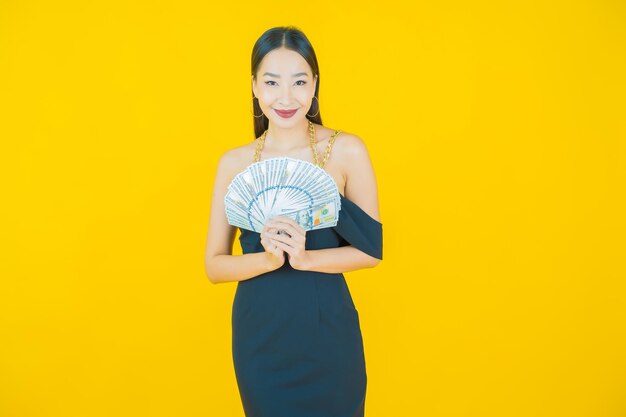 Retrato de hermosa mujer asiática joven sonrisa con mucho dinero en efectivo y dinero