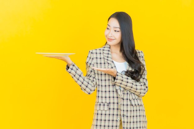 Retrato hermosa mujer asiática joven sonrisa con plato plato vacío