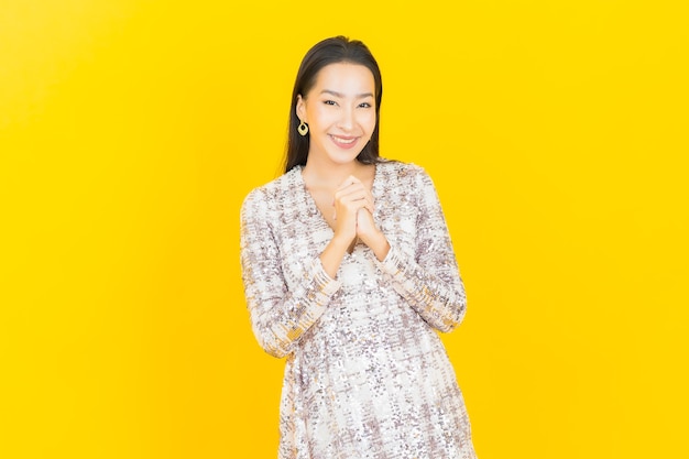 Retrato hermosa mujer asiática joven sonrisa posando en amarillo