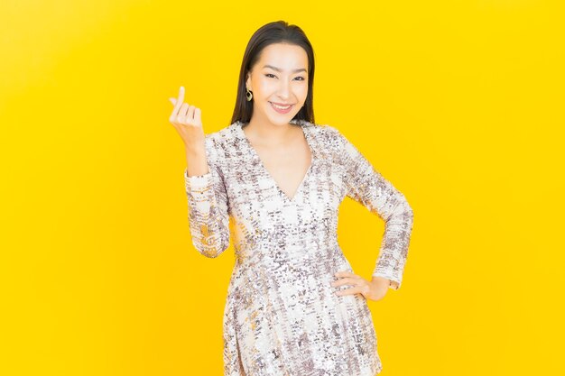 Retrato hermosa mujer asiática joven sonrisa posando en amarillo