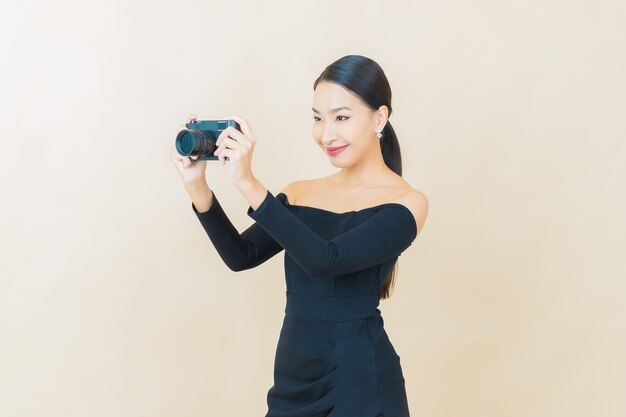 Retrato hermosa mujer asiática joven usar cámara en amarillo