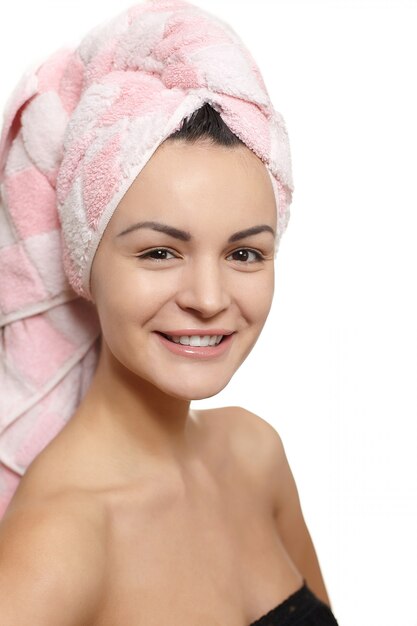 Retrato de hermosa mujer caucásica sonriente en toalla en la cabeza aislada en blanco studio