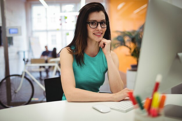 Retrato de la hermosa mujer ejecutiva sienta en su escritorio