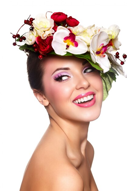 Retrato de hermosa mujer joven con estilo con coloridas flores en la cabeza.