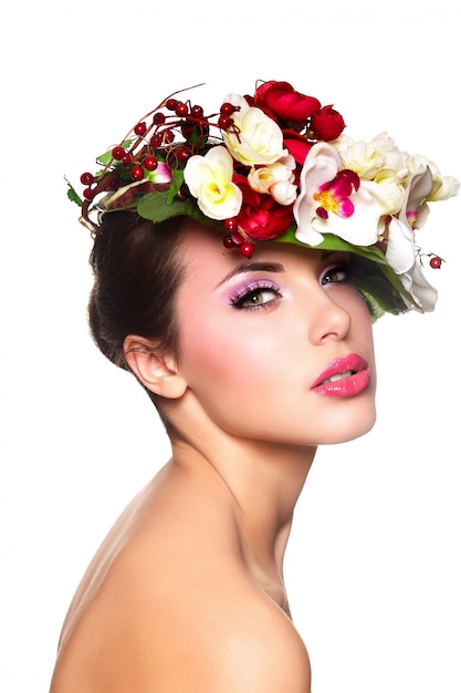 Retrato de hermosa mujer joven con estilo con coloridas flores en la cabeza.