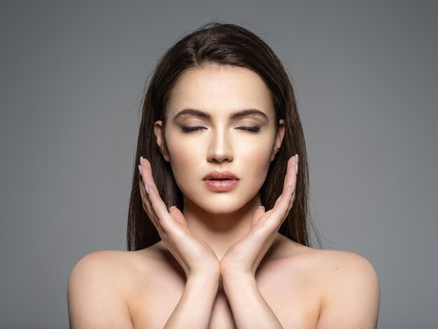 Retrato de hermosa mujer joven morena con rostro limpio. Cara tranquila. Bonita modelo de ojos cerrados. Meditación