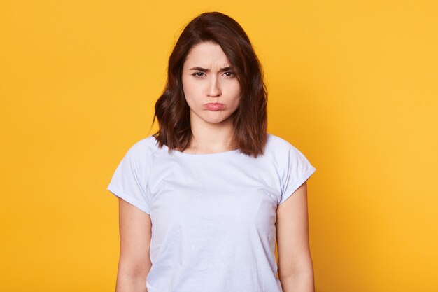 Retrato de hermosa mujer joven de pelo oscuro en camiseta blanca casual