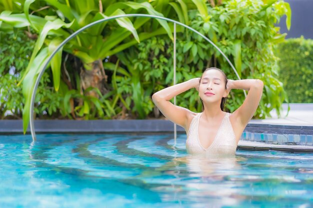 Retrato de hermosa mujer joven relajándose en la piscina