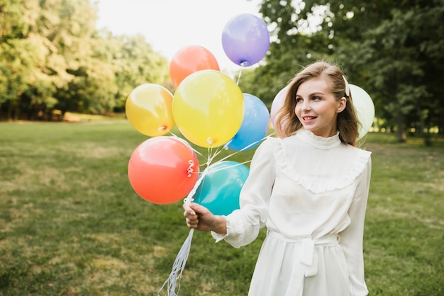 Retrato hermosa mujer oudoors con globos