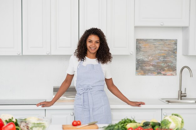 Retrato de hermosa mujer de pie en la cocina