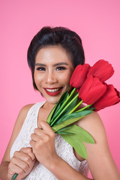 Retrato de hermosa mujer con ramo de flores de tulipán rojo