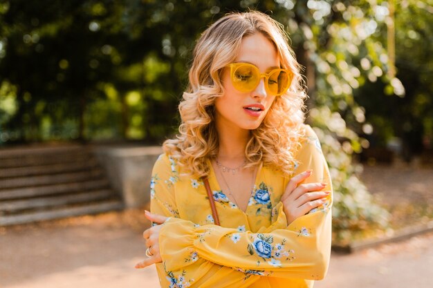 Retrato de hermosa mujer rubia elegante en blusa amarilla con gafas de sol, tendencia de moda de verano colorido, día soleado