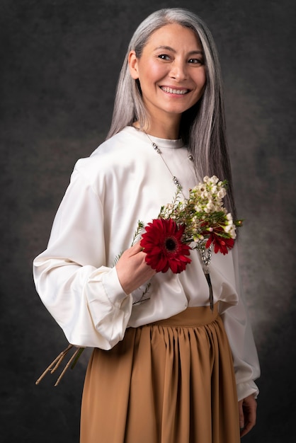 Foto gratuita retrato de hermosa mujer senior con flores