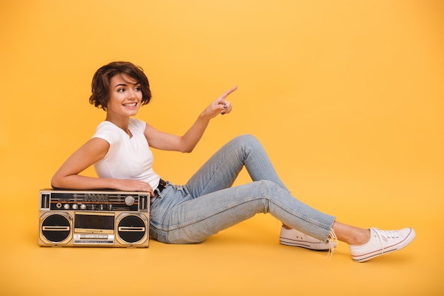 Retrato de una hermosa mujer sonriente sentada con tocadiscos