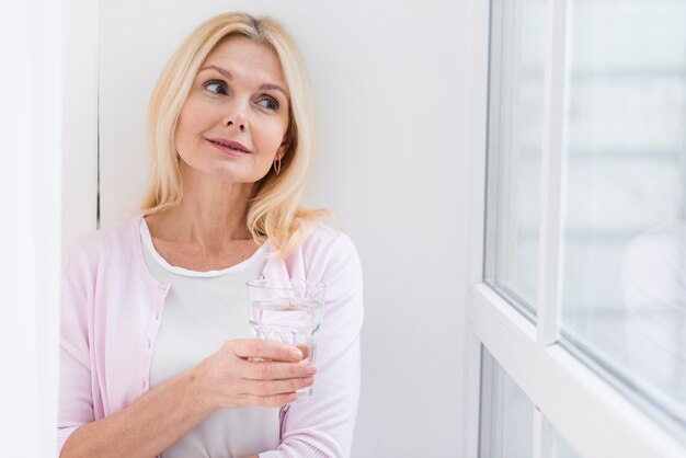 Retrato de hermosa mujer sosteniendo un vaso de agua