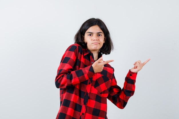 Retrato de una hermosa niña apuntando hacia la derecha