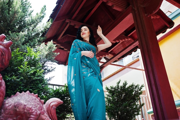 Foto gratuita retrato de hermosa niña brumette india o modelo de mujer hindú contra la casa tradicional japonesa y la figura del dragón