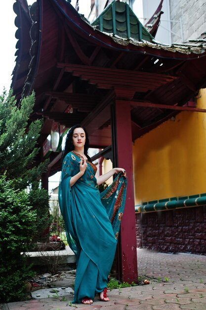 Retrato de hermosa niña brumette india o modelo de mujer hindú contra la casa tradicional japonesa