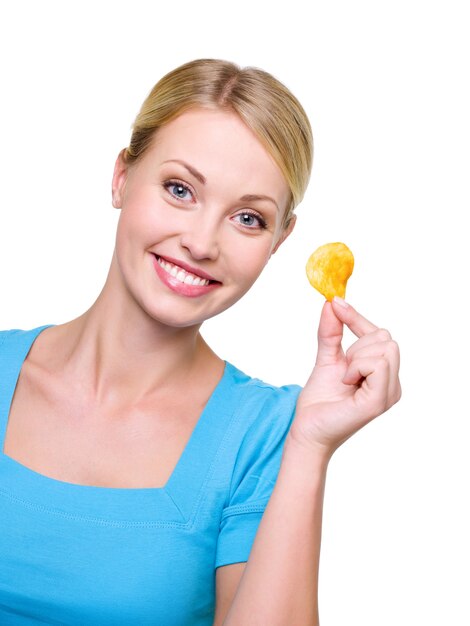 Retrato de una hermosa niña sonriente con un chip en la mano