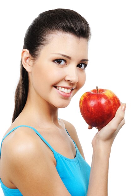 Retrato de hermosa niña sonriente comiendo manzana - aislado